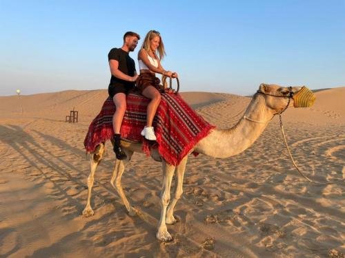 couple enjoying a camel ride on an evening safari dubai