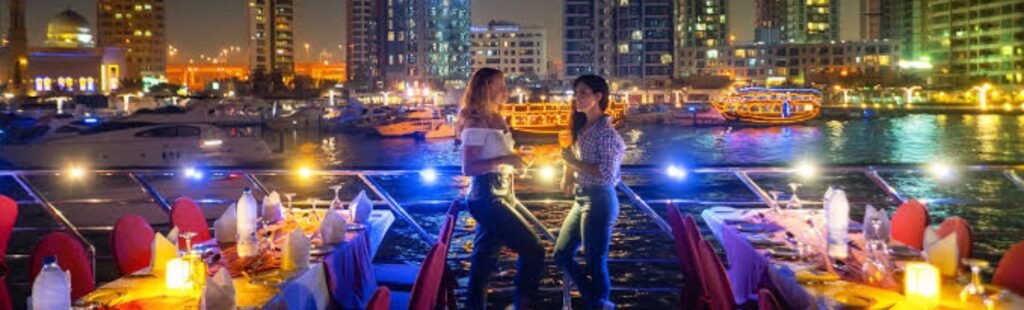 The illuminated Dubai skyline at night, seen from a dhow dinner cruise.