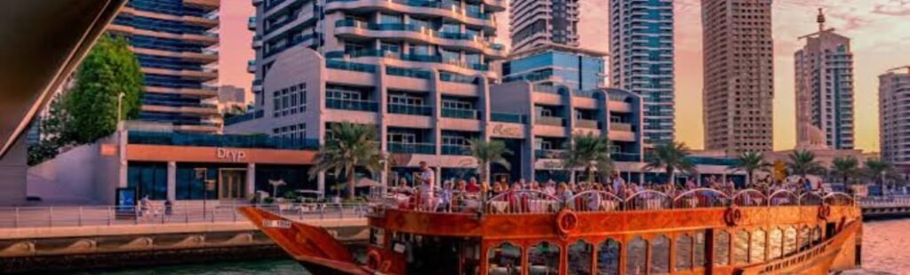 A dhow boat cruise at night with Dubai's illuminated skyline.