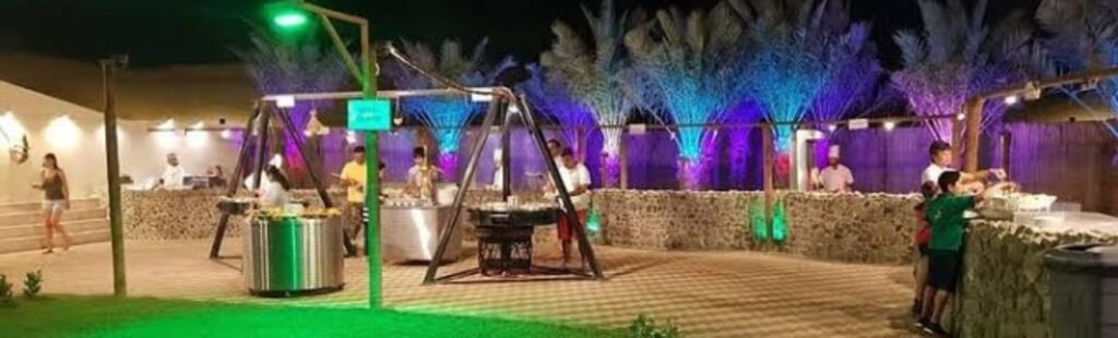 Guests enjoying Arabic coffee and dates in a desert setting.