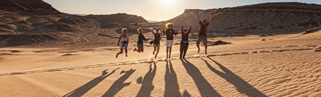 Guests participating in sandboarding in the Dubai desert.