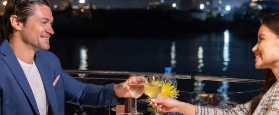 Dhow Boat Tour with Dubai skyline at sunset.