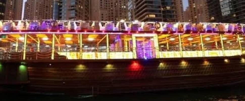 Dhow Cruise with dinner setup and Dubai skyline at dusk.