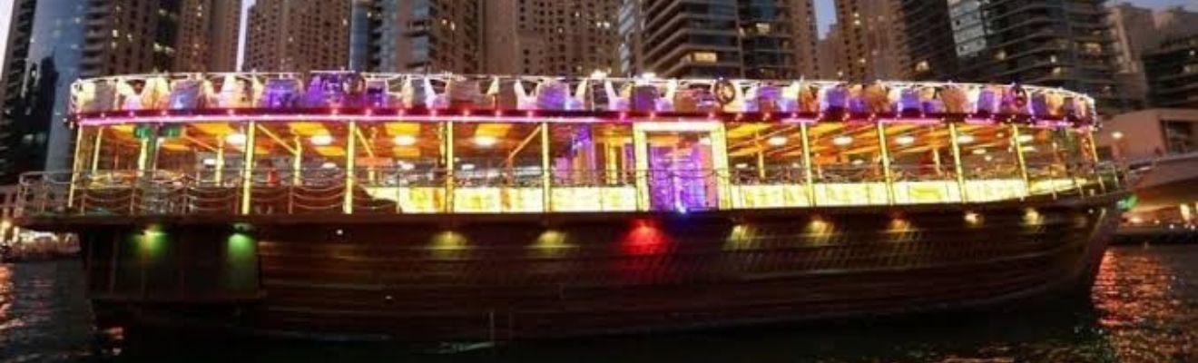 Dhow Cruise with dinner setup and Dubai skyline at dusk.