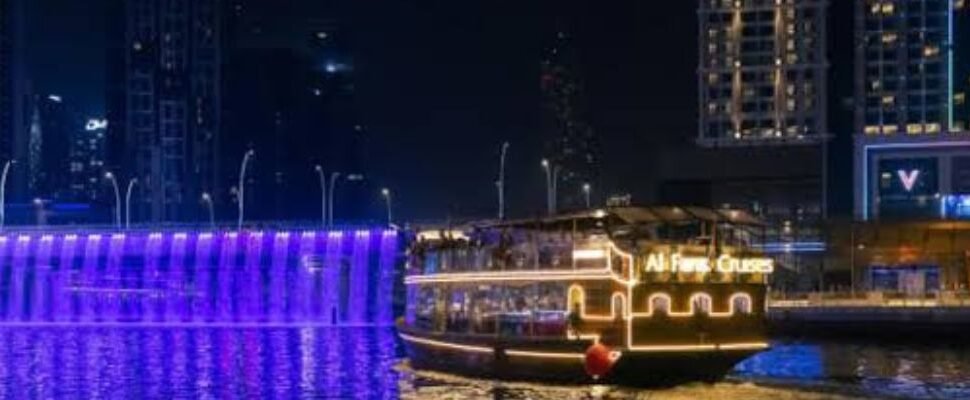 Dhow Boat Cruise sailing along Dubai's skyline at night.