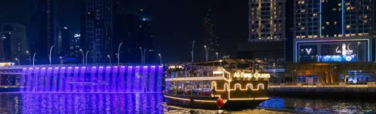 Dhow Boat Cruise sailing along Dubai's skyline at night.