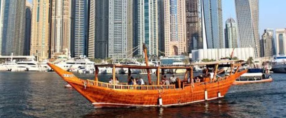 Marina Cruise sailing along Dubai's waterfront at sunset.