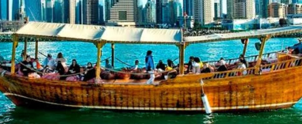 Marina Dhow Cruise sailing along Dubai's waterfront at sunset.