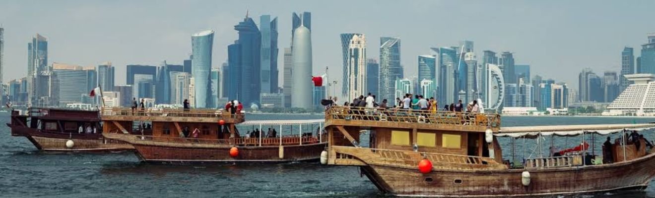 Dhow Cruise sailing on Dubai Creek at sunset.