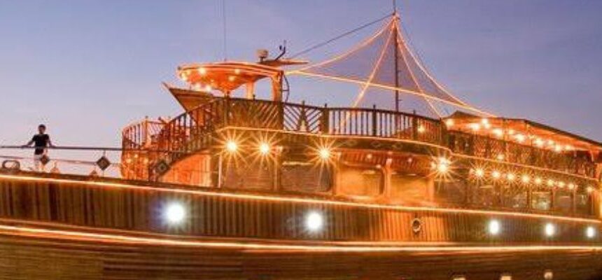 Dhow Cruise sailing against Dubai's illuminated skyline.