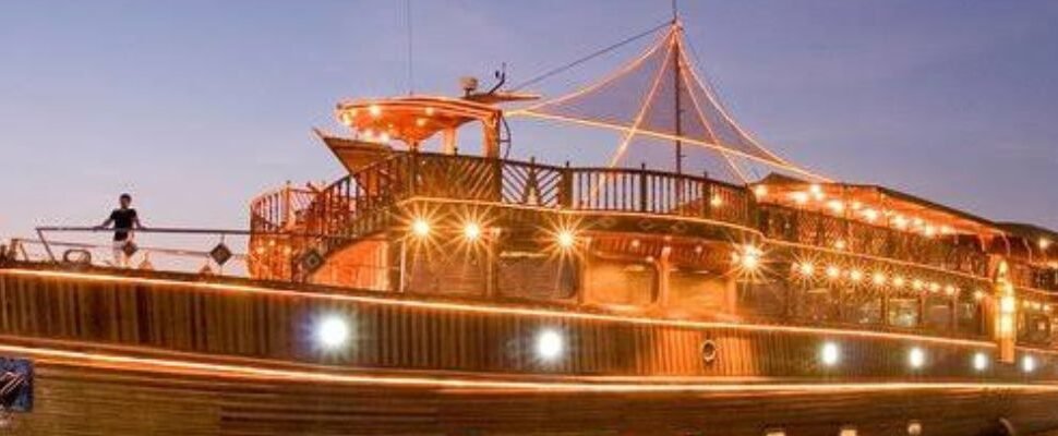 Dhow Cruise sailing against Dubai's illuminated skyline.