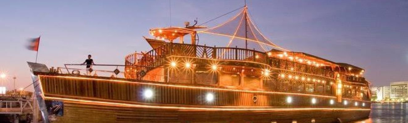 Dhow Cruise sailing against Dubai's illuminated skyline.