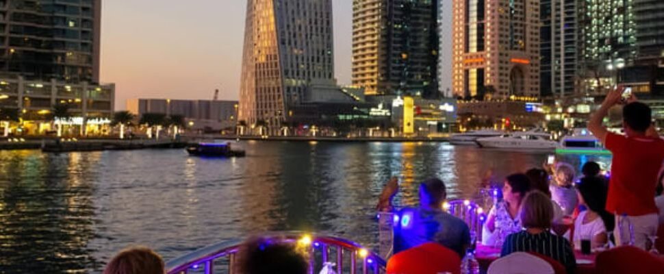 Dhow Cruise sailing on Dubai Creek at sunset.