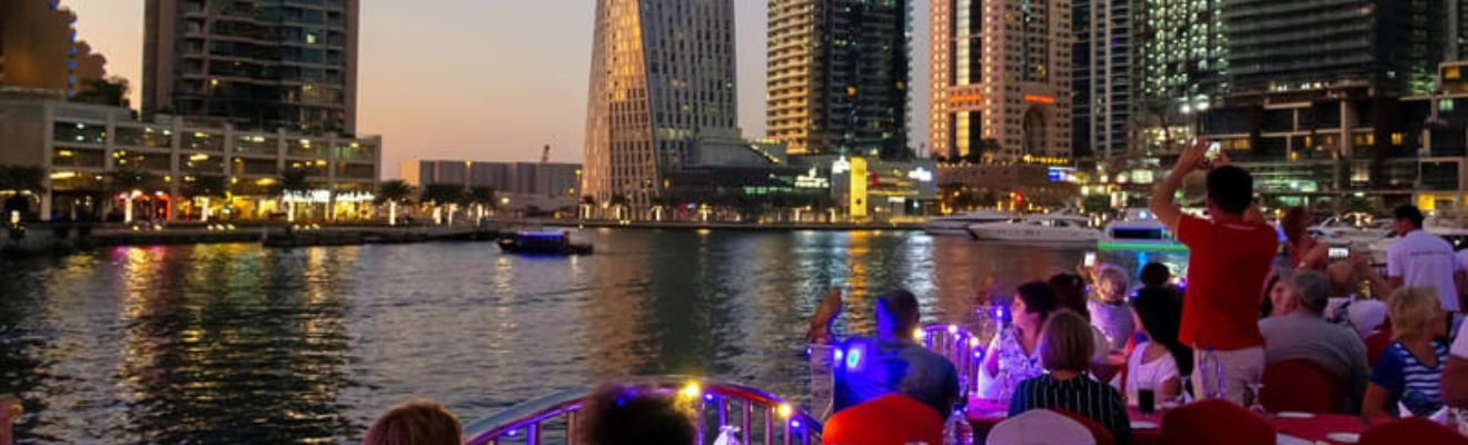 Dhow Cruise sailing on Dubai Creek at sunset.