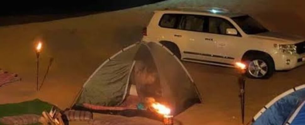 Safari Dubai vehicle driving through desert dunes.