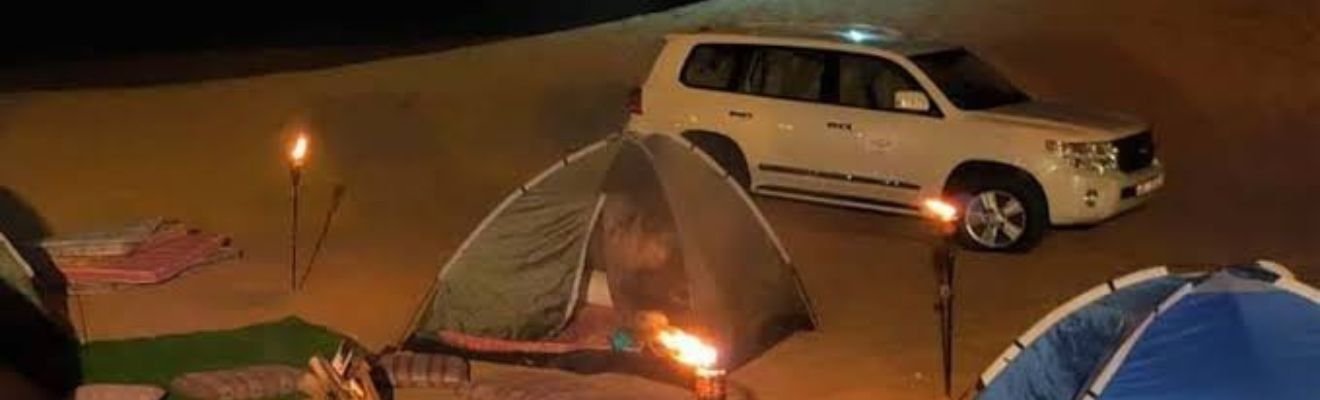 Safari Dubai vehicle driving through desert dunes.