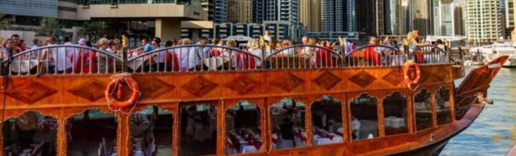 Night view of the Creek Dhow Dinner Cruise illuminated in Dubai Creek.