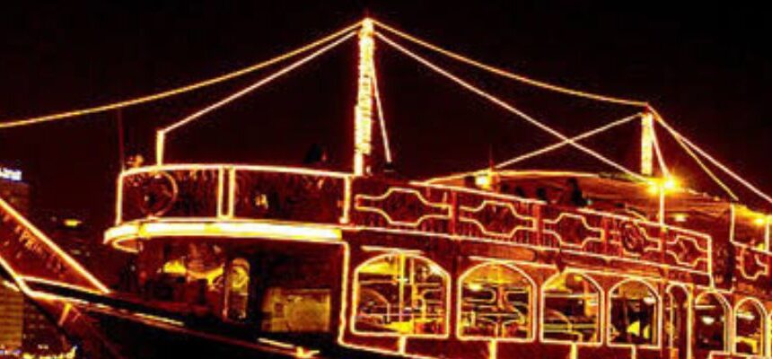 Dhow Cruise Booking Online › Forever Tourism LLC Dhow Cruise sailing at sunset with Dubai skyline.