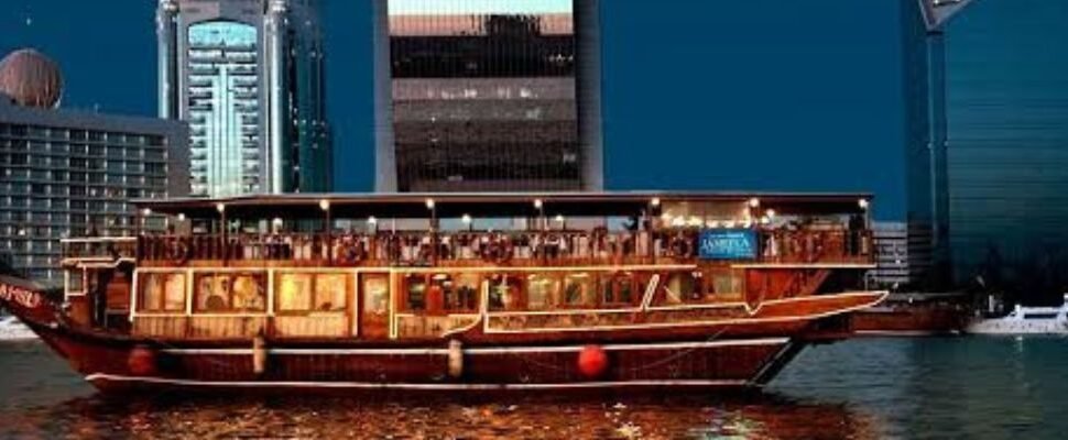 Cruise Creek boat sailing through Dubai Creek at sunset.