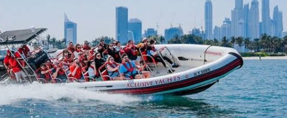 Marina boat sailing with Dubai skyline in the background.