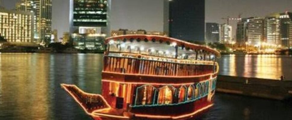 Dhow Cruise sailing on Dubai Creek at sunset.