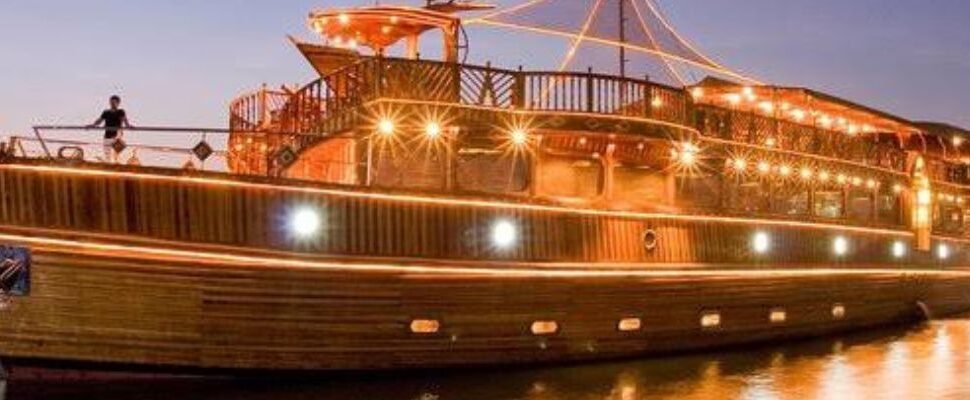 Luxury Dhow Cruise sailing on Dubai’s waters at twilight.