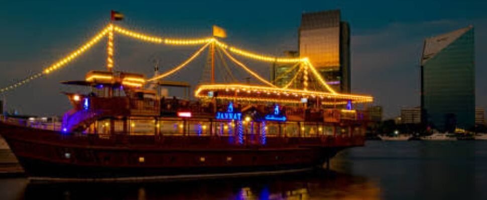 Exclusive Dhow Cruise sailing through Dubai’s waters at night.