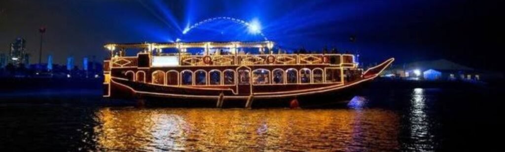 Night view of an illuminated dhow cruise in Dubai.