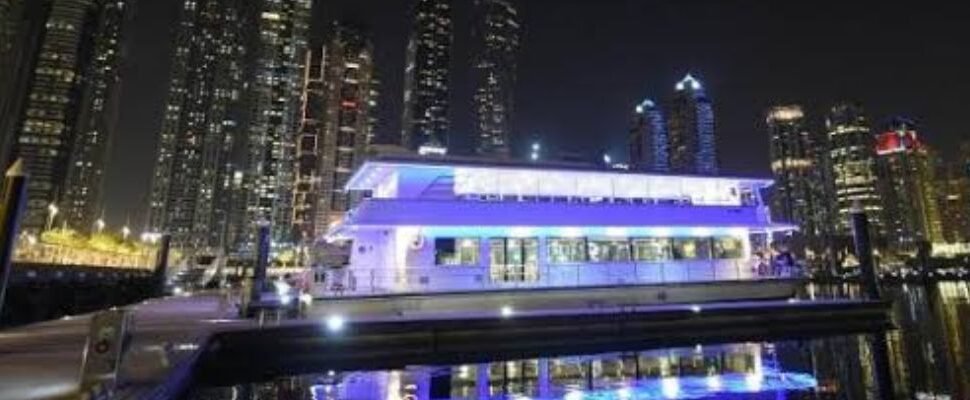 Luxury Marina Boat Cruise with Dubai skyline at sunset.