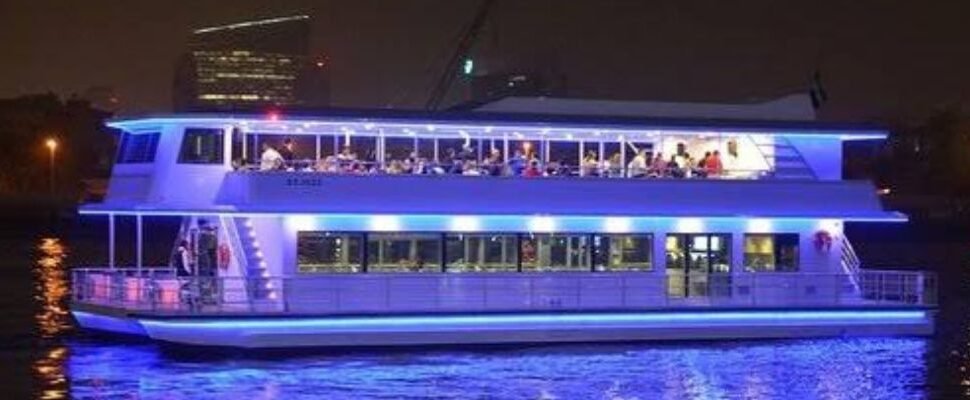 Luxury Marina Cruise boat with Dubai skyline in the background.