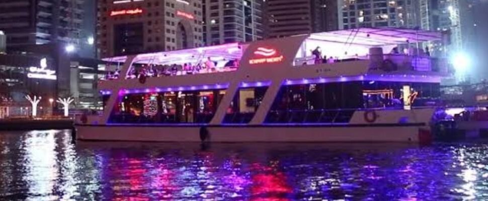 Traditional dhow boat sailing in Dubai's waters at sunset.