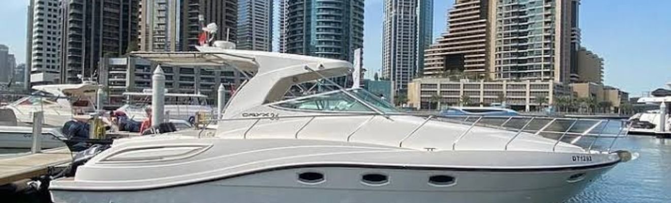 Luxury yacht cruising through Dubai Marina at dusk.