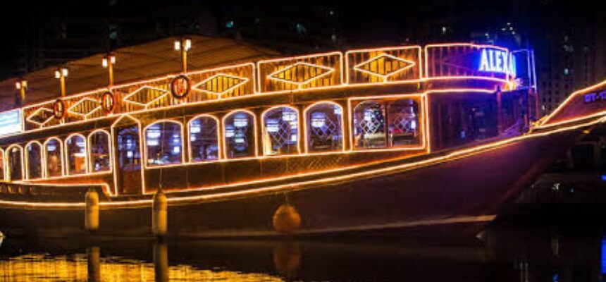 A traditional dhow boat sailing through Dubai Marina at sunset.