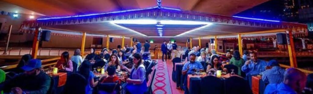 Guests enjoying dinner on the deck of the Marina Dhow Cruise.