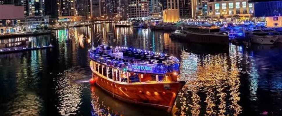 A traditional dhow sailing through Dubai Marina at dusk.