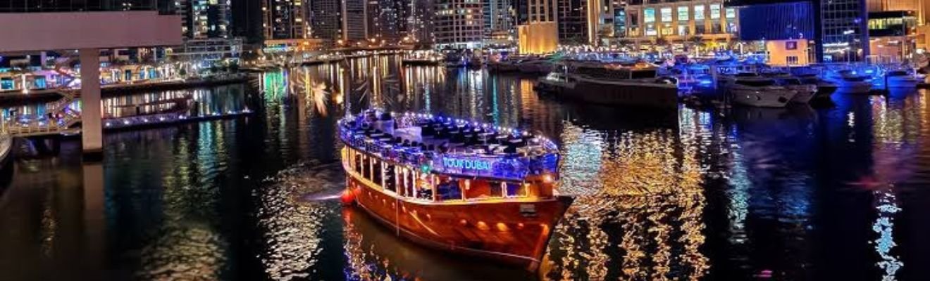 A traditional dhow sailing through Dubai Marina at dusk.