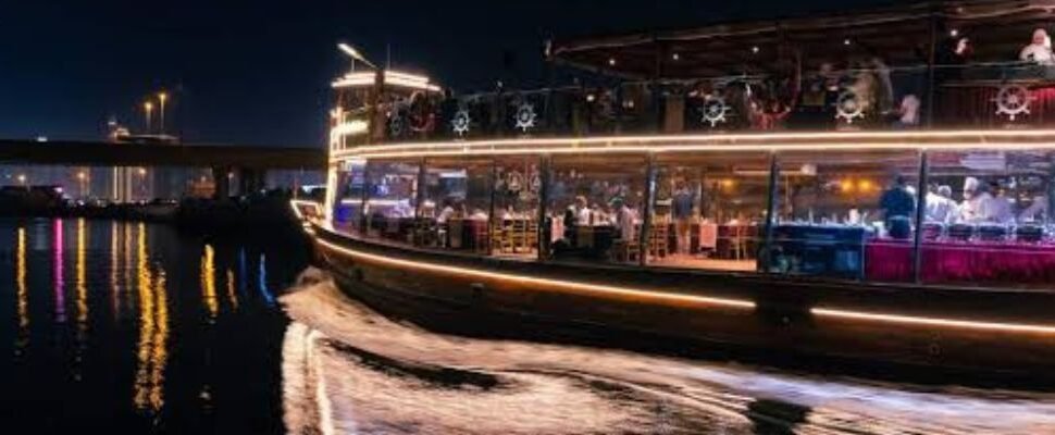 A luxury yacht cruising down the Dubai Canal at sunset.