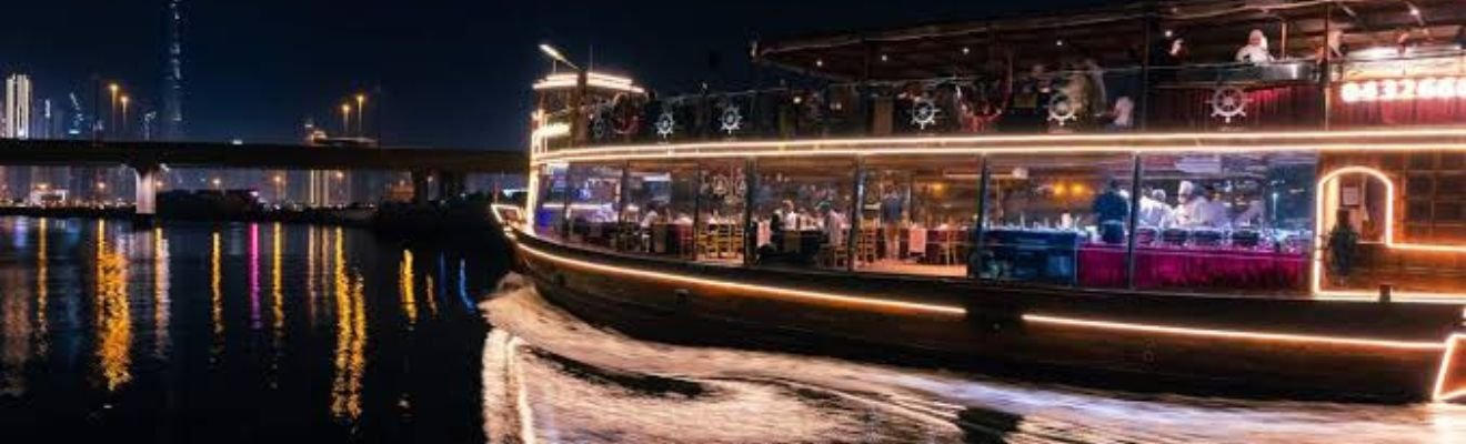 A luxury yacht cruising down the Dubai Canal at sunset.