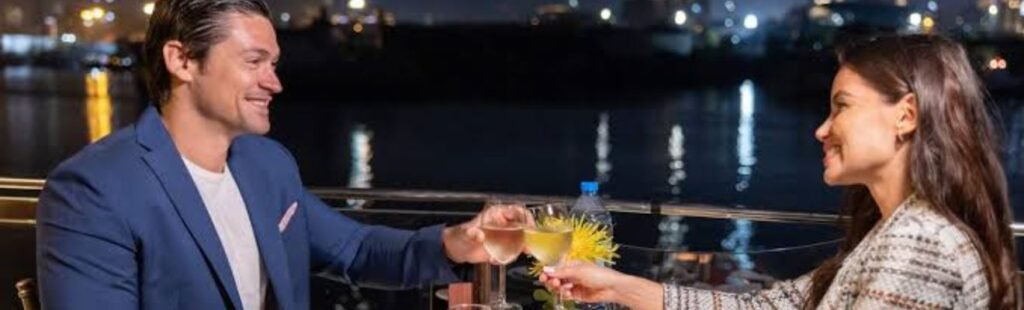 A couple holding hands as they walk along the cruise deck.