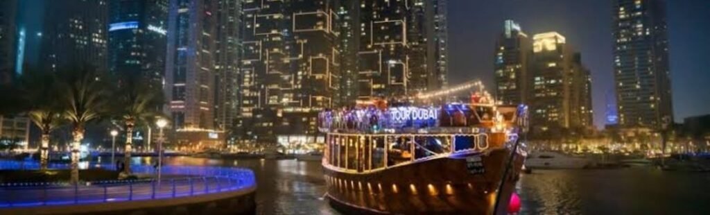 Aerial view of Dubai Creek with illuminated dhows at night.