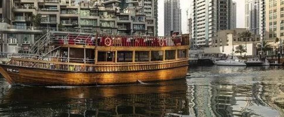 Traditional dhow boat cruising on Dubai Creek.