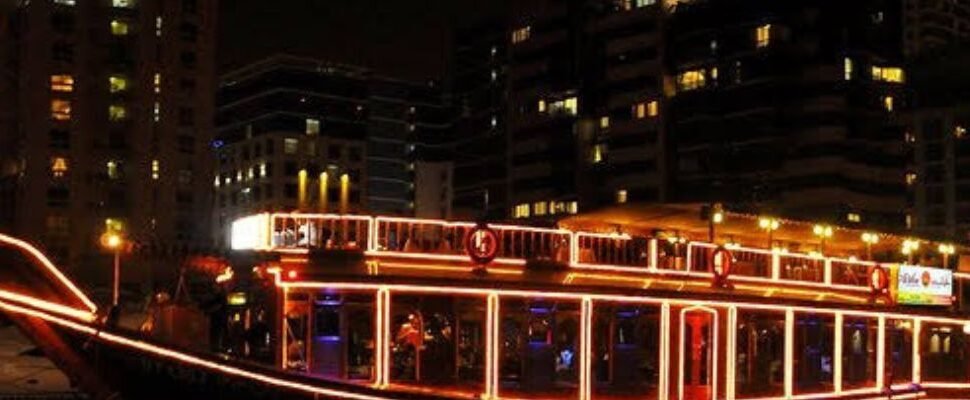 A dhow boat illuminated at night, cruising through Dhow Cruise Dubai Marina Cost: The Best Kept Secret!.