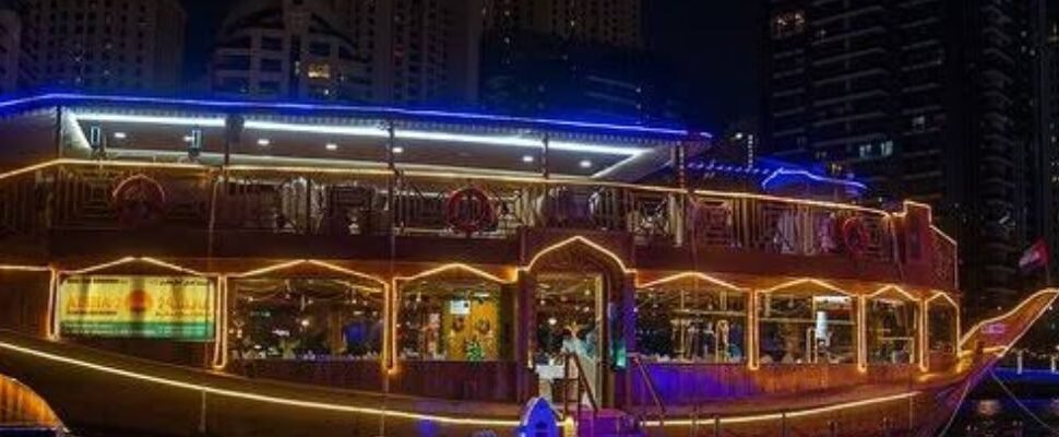 Traditional dhow cruise sailing through Dubai's modern skyline.