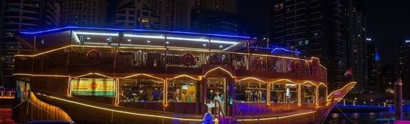 Traditional dhow cruise sailing through Dubai's modern skyline.