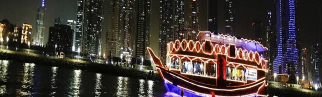 Aerial view of Dubai Marina at night with a cruise ship.