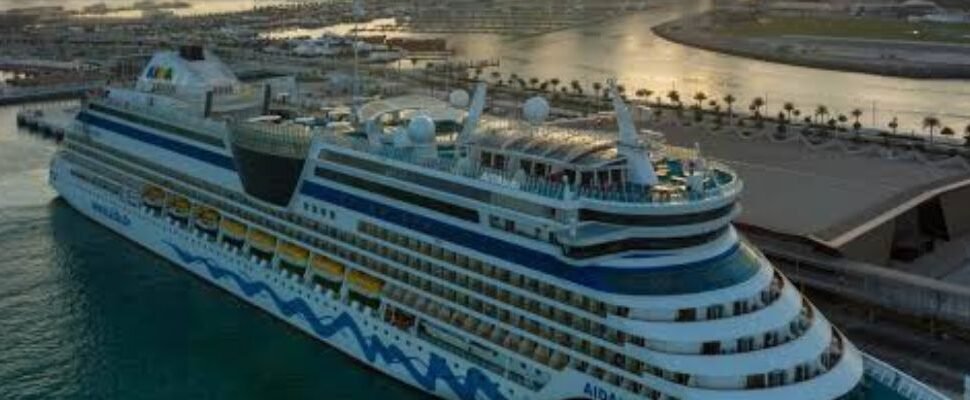 Cruise ship sailing through Dubai Marina at sunset.