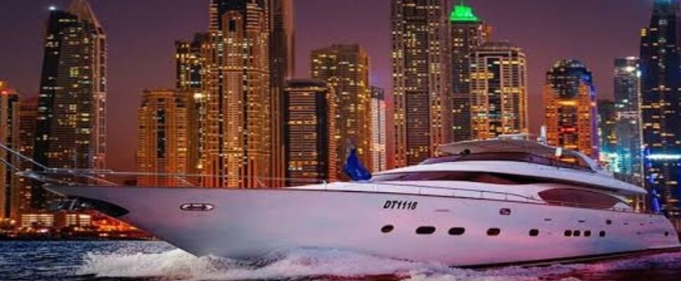 A luxury yacht cruising through Dubai Marina under a clear blue sky.