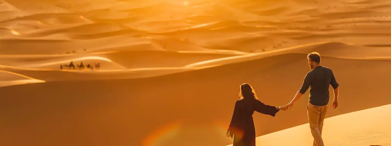 A thrilling Dubai Desert Safari experience featuring a camel ride against the backdrop of golden sand dunes at sunset.