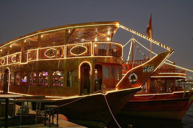 Scenic view of a beautifully lit Dhow Cruise sailing through Dubai Marina, offering a luxurious dining experience. Enjoy an unforgettable Dhow Cruise Dubai adventure with stunning skyline views and live entertainment.