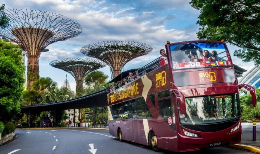Dubai sightseeing bus driving past city landmarks on a hop-on hop-off red bus tour in Dubai.